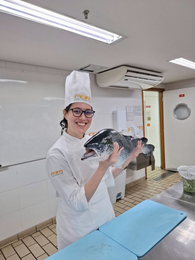 Eu segurando um salmão inteiro na sala de aula